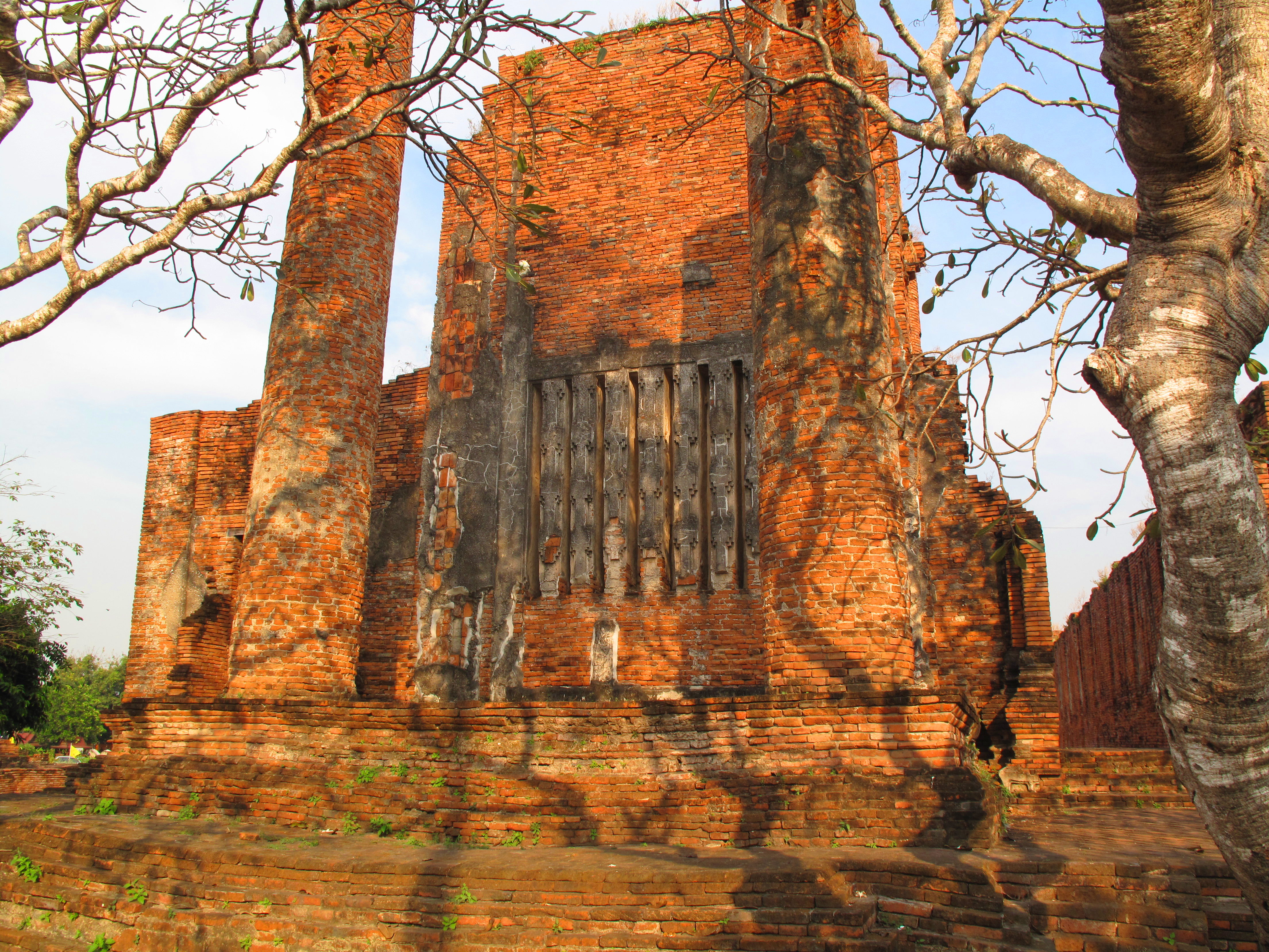 Rear wall of the prayer hall, framed by frangipani trees