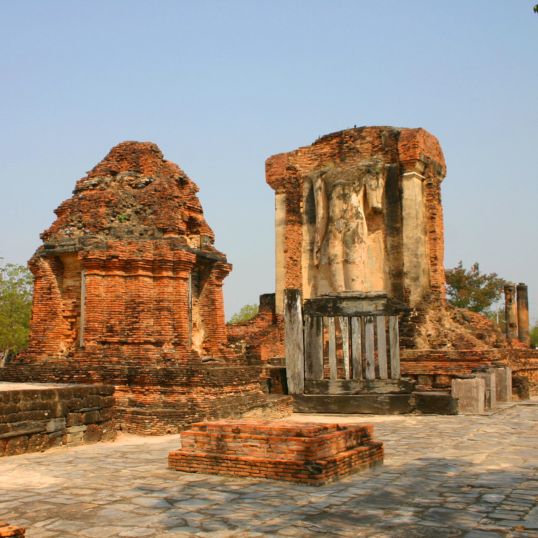 A standing Buddha image behind the walking Buddha at Wat Chetuphon